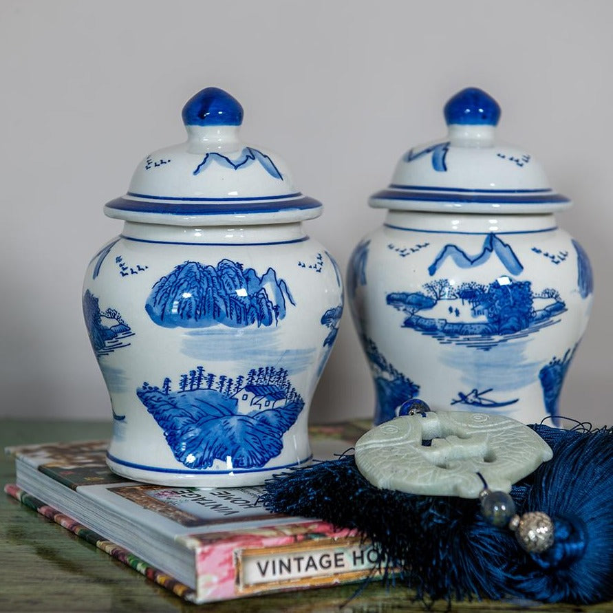 A small Chinese temple jar hand-painted in blue and white with a traditional landscape image. 