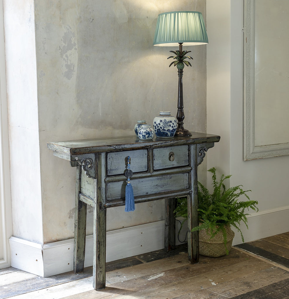antique grey chinese altar table with metal palm tree lamp and small ginger jars