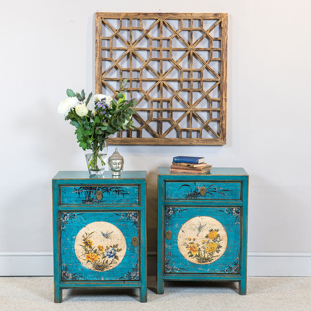 A pair of blue side cabinets featuring a single drawer, brass handles and hand-painted with an Oriental floral design.