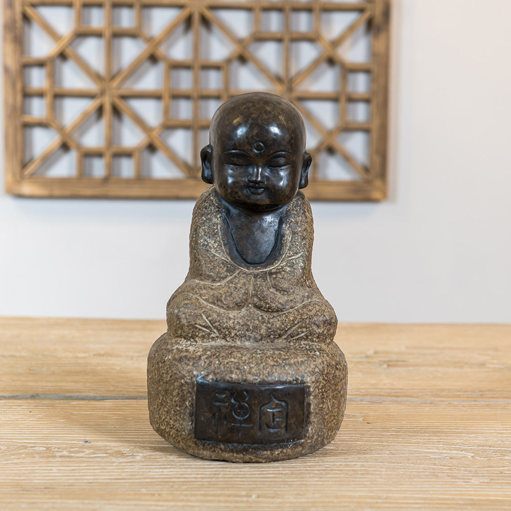 A hand-carved granite statue of a meditating Monk.