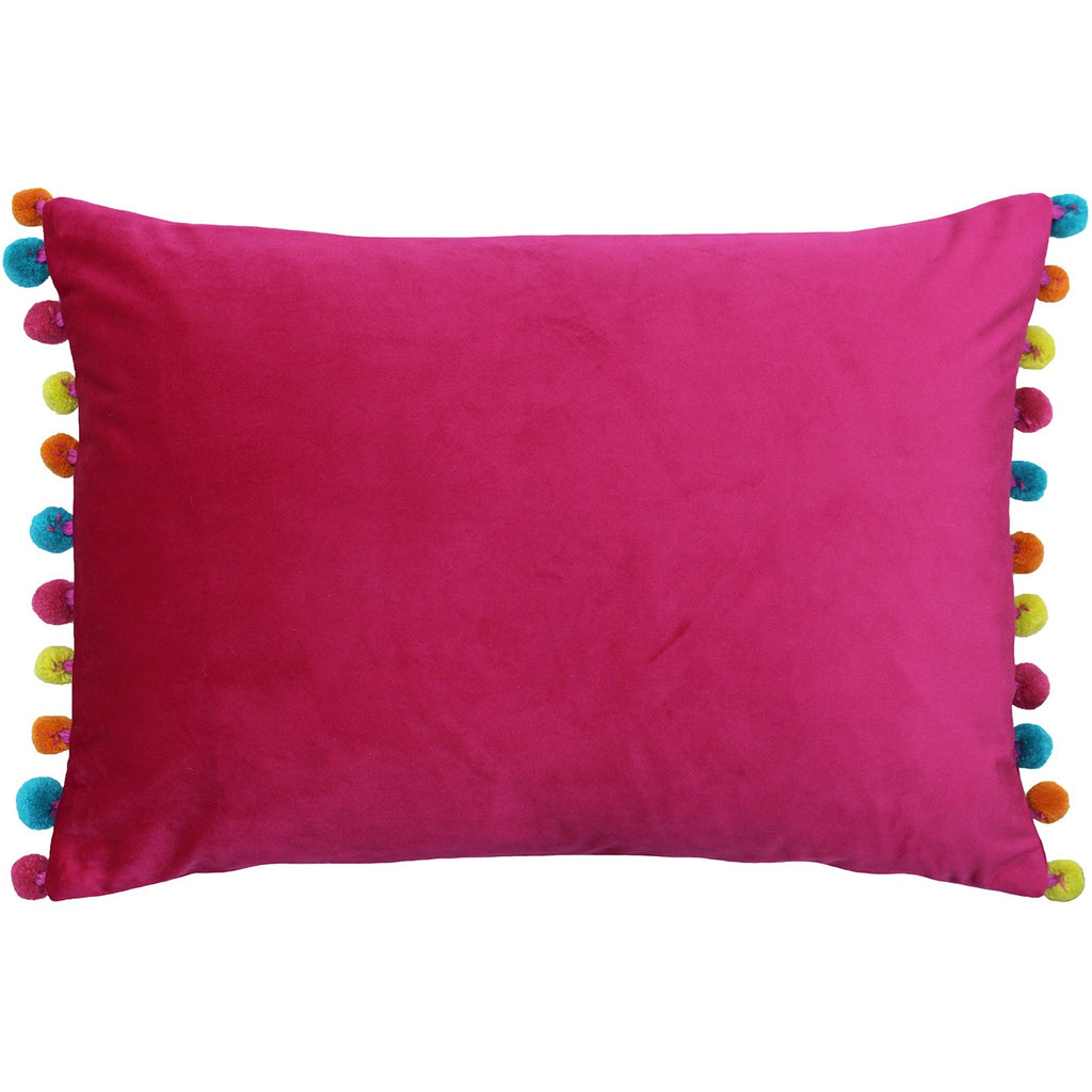 A rectangular cushion with a pink velvet cover with multicoloured pom poms at the edges. 