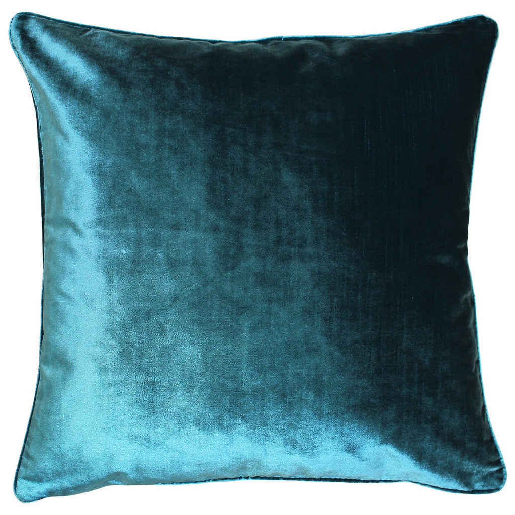 A shiny square cushion with a teal velvet cover edged in navy piping. 