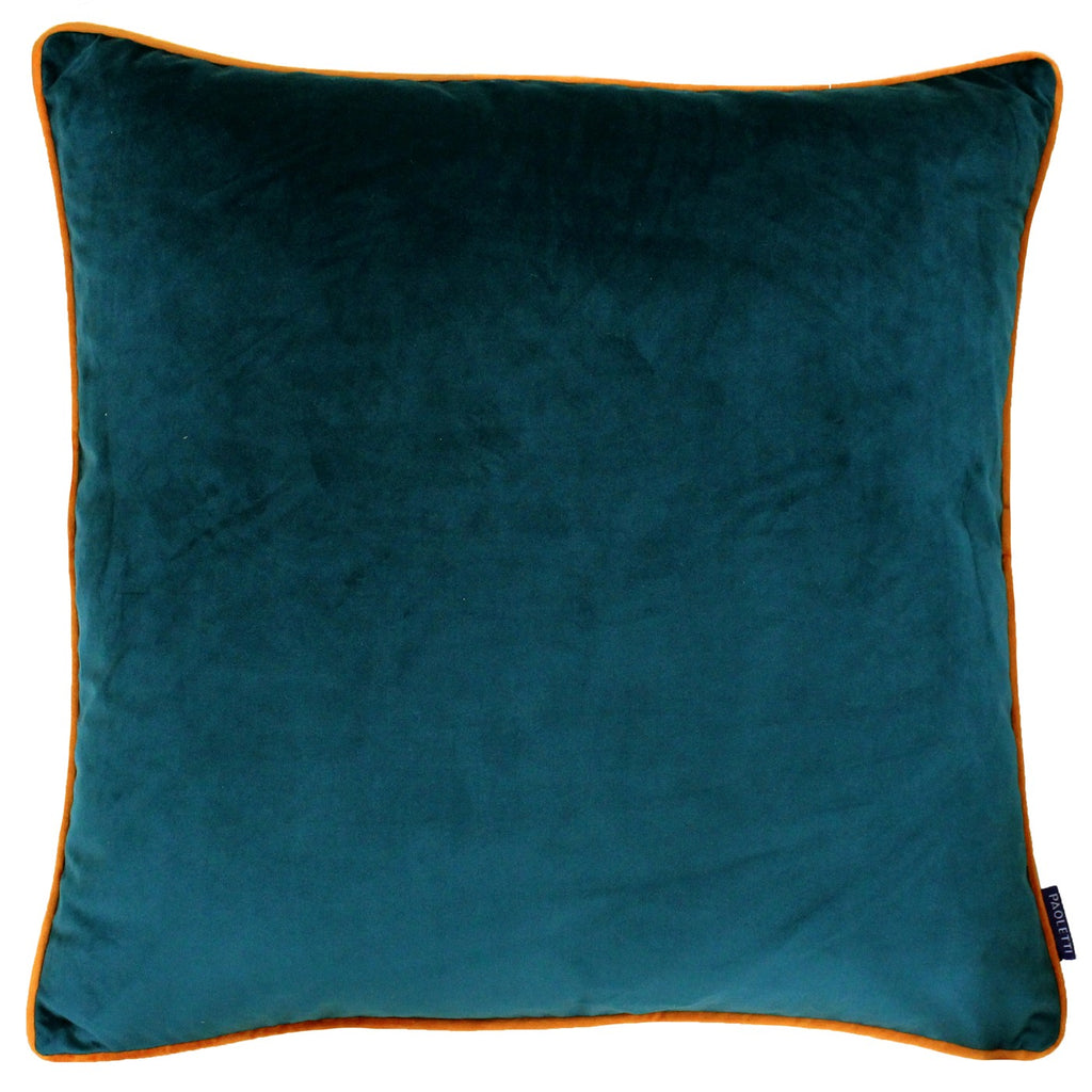 A large square cushion with a teal velvet cover edged with orange piping. 
