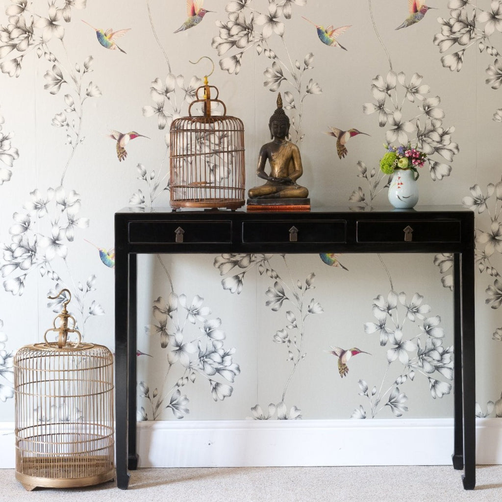 This three drawer, slim console table is finished in a high-gloss black lacquer. 