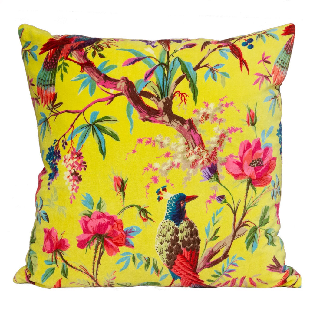 A large square cushion with a bright yellow velvet cover, decorated in tropical birds and flora.