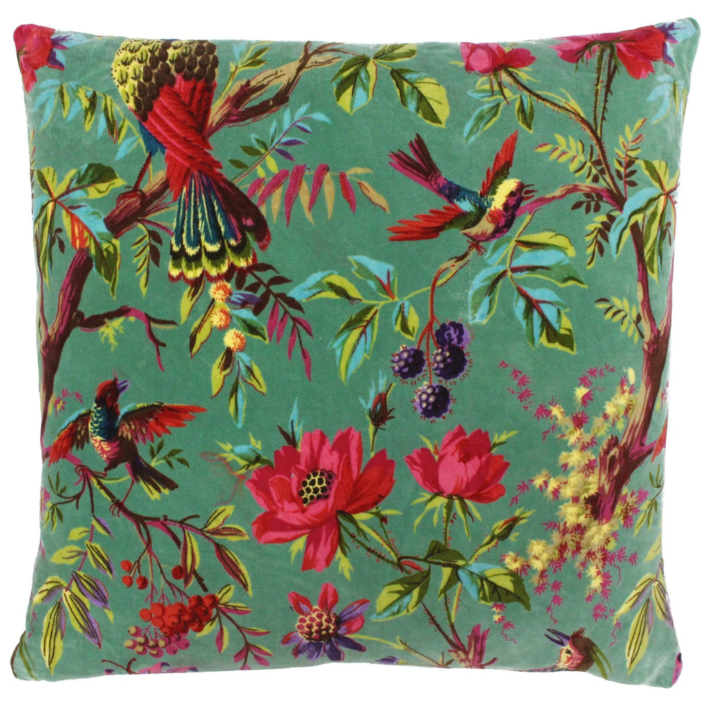 A large square cushion with a turquoise cover decorated in parrots and tropical flowers. 