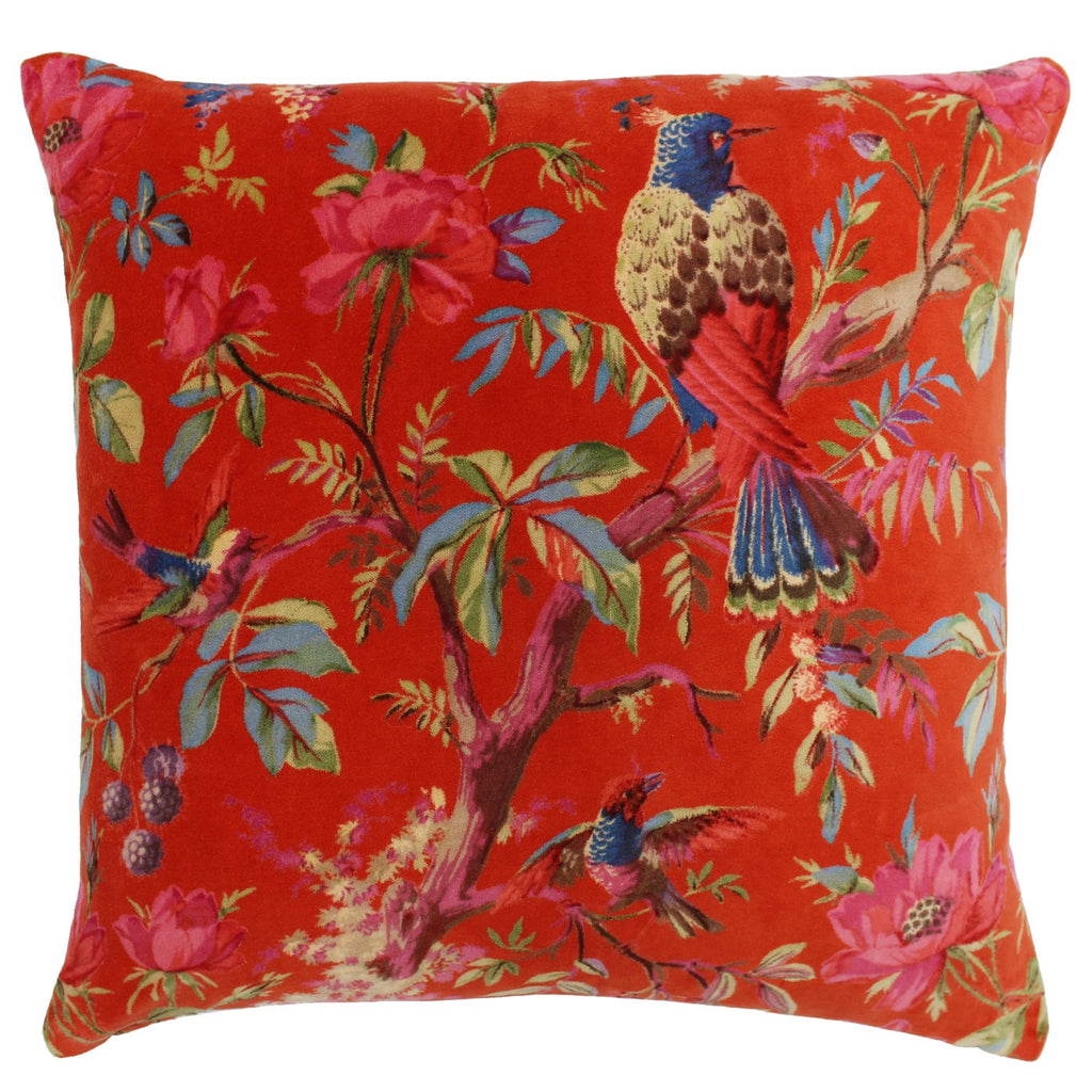A square cushion with an orange, velvet cover decorated in vibrant birds and flora. 