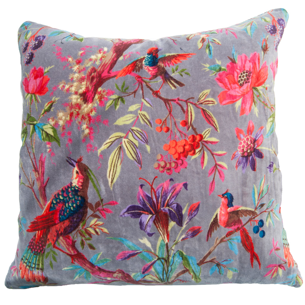 A large square cushion with a soft grey velvet cover, decorated in colourful birds and flowers. 